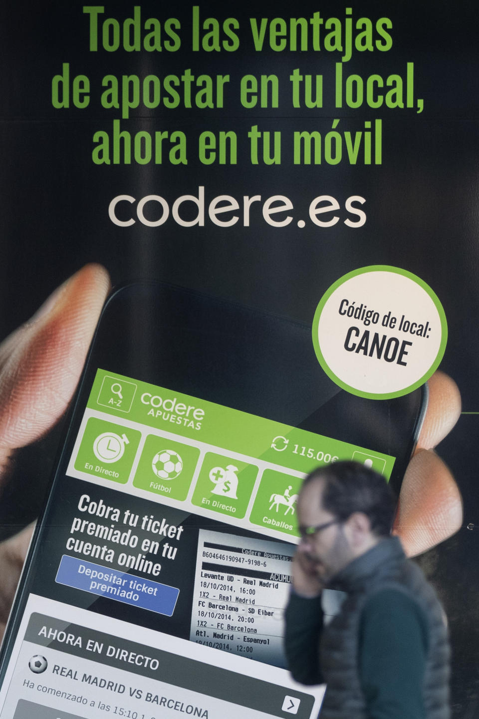 A man walks past an advertisement for online betting on the outside of a betting shop in Madrid, Spain, Friday, Feb. 21, 2020. Spain’s government has announced plans to restrict advertising for on-line betting houses on the Internet, television, and during sporting events. The government said Friday that the law would be the most restrictive in the European Union. (AP Photo/Paul White)
