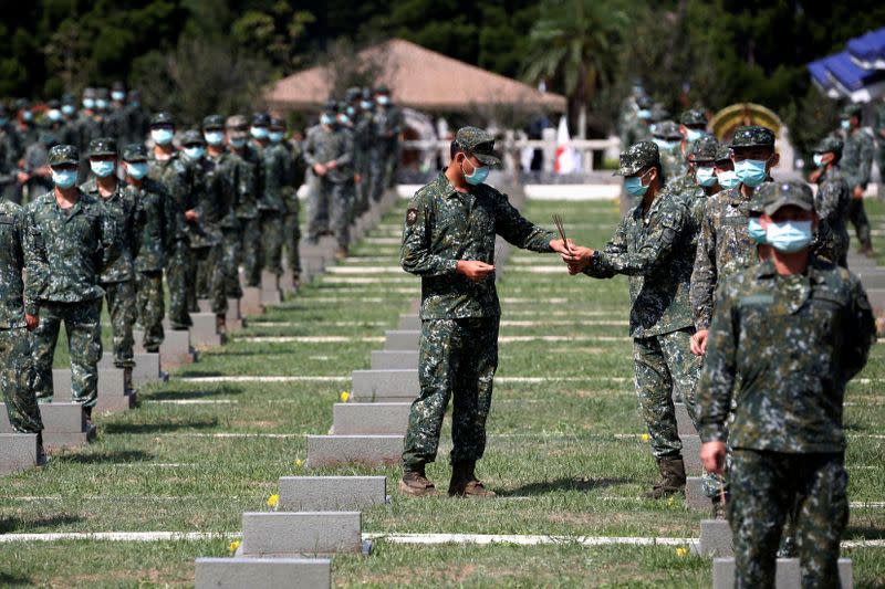 Soldiers pass incense to each other to pay respects to the deceased, during an event to mark the 62nd anniversary of the Second Taiwan Strait crisis in Kinmen, Taiwan