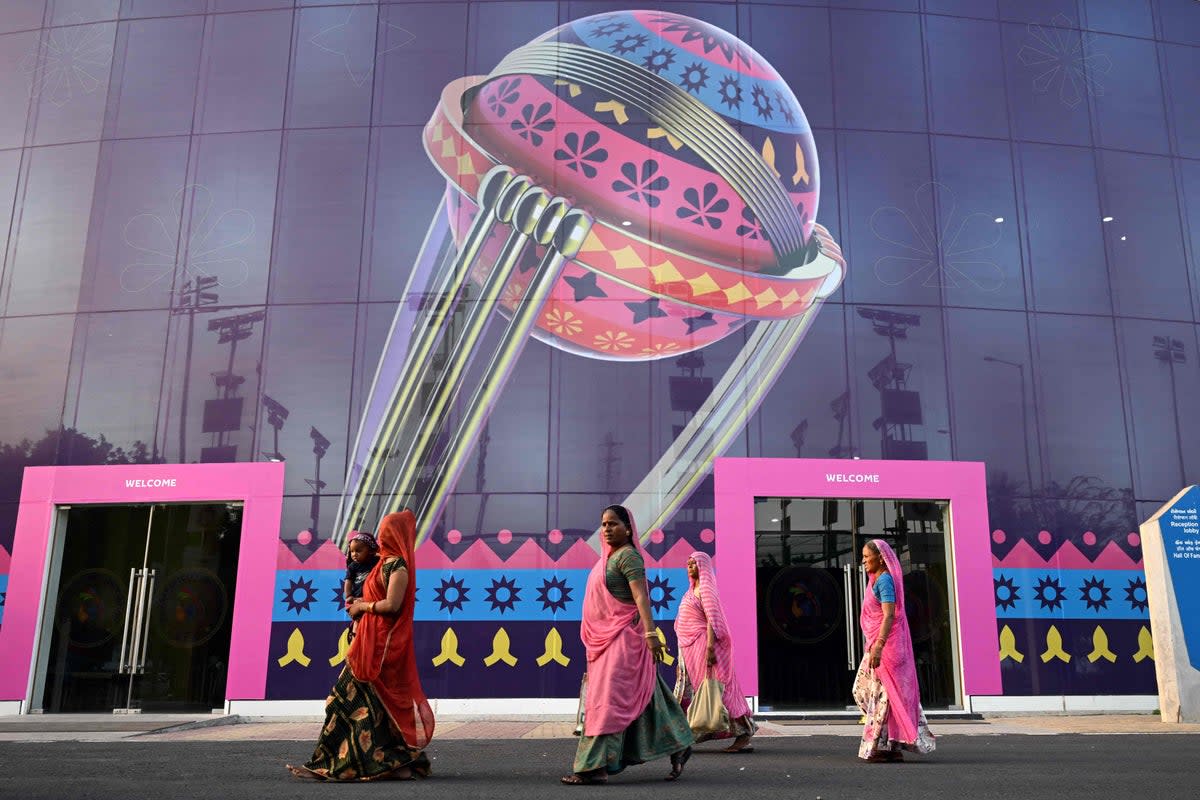 Women along with a child walk inside the complex of the Narendra Modi Stadium ahead of the 2023 ICC men's cricket World Cup, in Ahmedabad on 2 October 2023 (AFP via Getty Images)