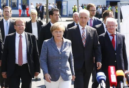 Heidenau major Juergen Opitz, German Chancellor Angela Merkel, Saxony State Prime Minister Stanislaw Tillich and President of the German Red Cross Rudolf Seiters (LtoR) arrive for statements after their visit to an asylum seekers accomodation facility in the eastern German town of Heidenau near Dresden, August 26, 2015. REUTERS/Axel Schmidt