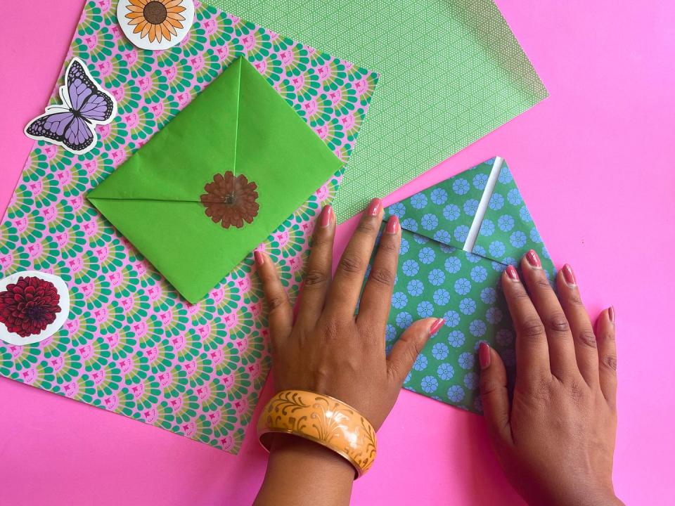 two hands folding down paper to make an envelope