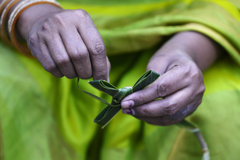 A Catholic devotee makes a cross with palm leaves during a Palm Sunday Mass at the St. Joseph Cathedral in Hyderabad, India, Sunday, March 24, 2024. Palm Sunday marks the sixth and last Sunday of the Christian Holy month of Lent. (AP Photo/Mahesh Kumar A.)