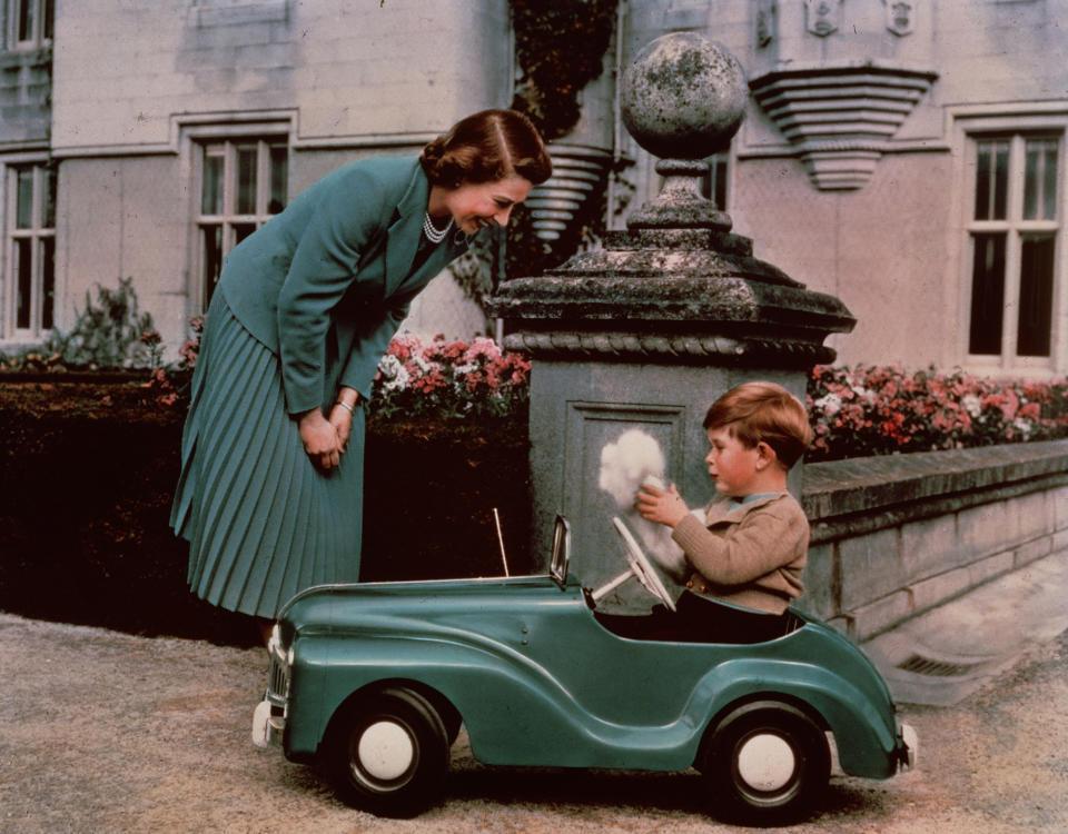 <p>The Queen is seen here at Balmoral with a four-year-old Charles in his toy car.</p>