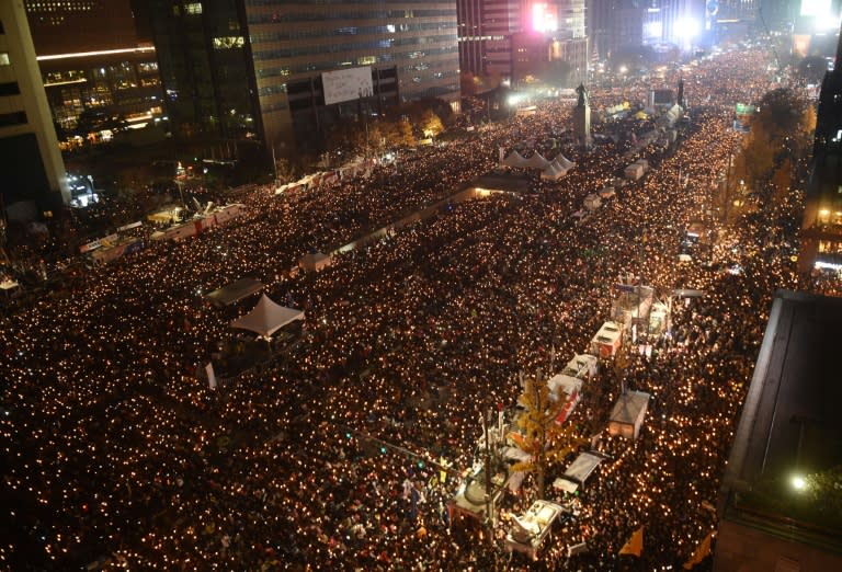 Tens of thousands of protesters hold candles during an anti-government rally in central Seoul on November 19, 2016