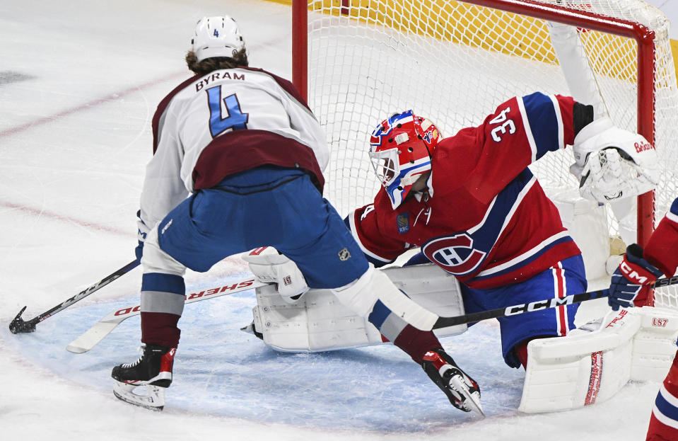 Colorado Avalanche's Bowen Byram (4) moves in to score against Montreal Canadiens goaltender Jake Allen during first-period NHL hockey game action in Montreal, Monday, March 13, 2023. (Graham Hughes/The Canadian Press via AP)