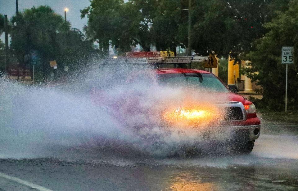 A truck splashes through a flooded portion of US-1 near 6th Avenue North in Lake Worth Beach early Saturday morning June 4, 2022. Heavy rainfall and possible flooding is expected throughout the day.