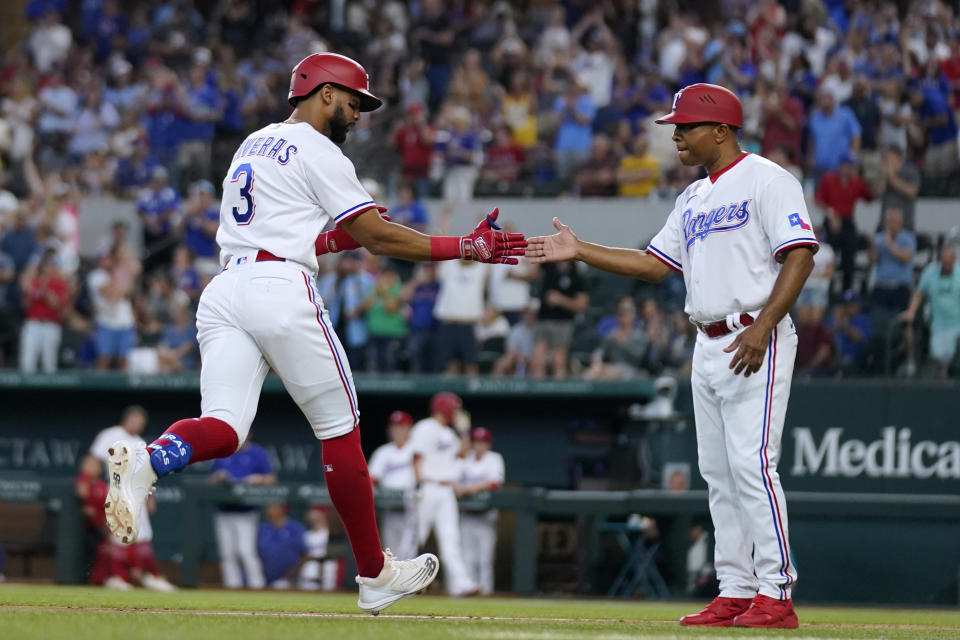 Texas Rangers' Leody Taveras and third base coach Tony Beasley, right, celebrate as Taveras runs the bases after hitting a three-run home run against the Seattle Mariners during the fifth inning of a baseball game Saturday, June 3, 2023, in Arlington, Texas. (AP Photo/Tony Gutierrez)