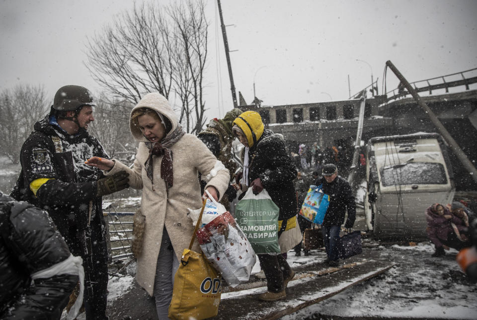 Ukrainian soldiers assist civilians as they continue to evacuate the town of Irpin, near Kyiv. 