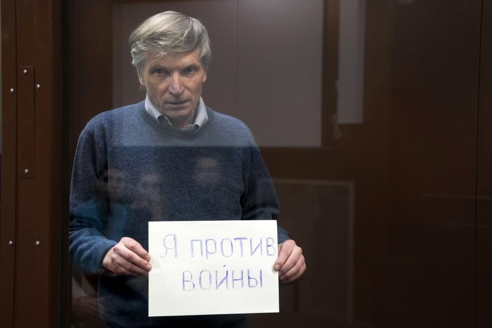 FILE - Alexei Gorinov, a former member of a Moscow municipal council, was convicted of "spreading false information" about the army, holds a sign "I am against the war" standing in a cage during hearing in the courtroom in Moscow, Russia, on June 21, 2022. Criticism of the invasion was criminalized a few months earlier, and Gorinov, 61, became the first Russian sent to prison for it, receiving seven years.Mercenary chief Yevgeny Prigozhin led an armed rebellion against the Russian military, but faced no prosecution. Others, who merely voice criticism against the Kremlin, aren't so lucky. (AP Photo, File)