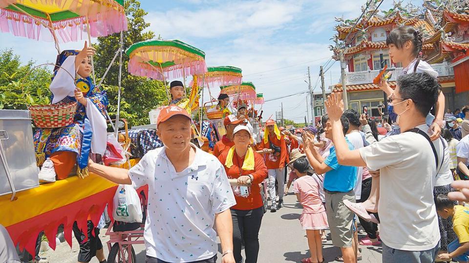 台南市列入國家無形文化資產的「西港刈香」已有240年歷史，今年逢甲辰年香科，25日是「百足真人」蜈蚣陣遶境第2天，蜈蚣陣上的神童沿路丟擲糖果，信眾夾道爭搶「呷平安」。（寶智華攝）