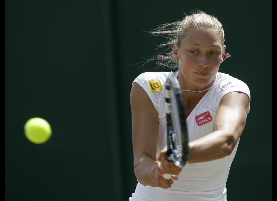 Yanina Wickmayer of Belgium returns a shot against Tamira Paszek of Austria during a third round women's singles match at the All England Lawn Tennis Championships at Wimbledon, England, Saturday, June 30, 2012.