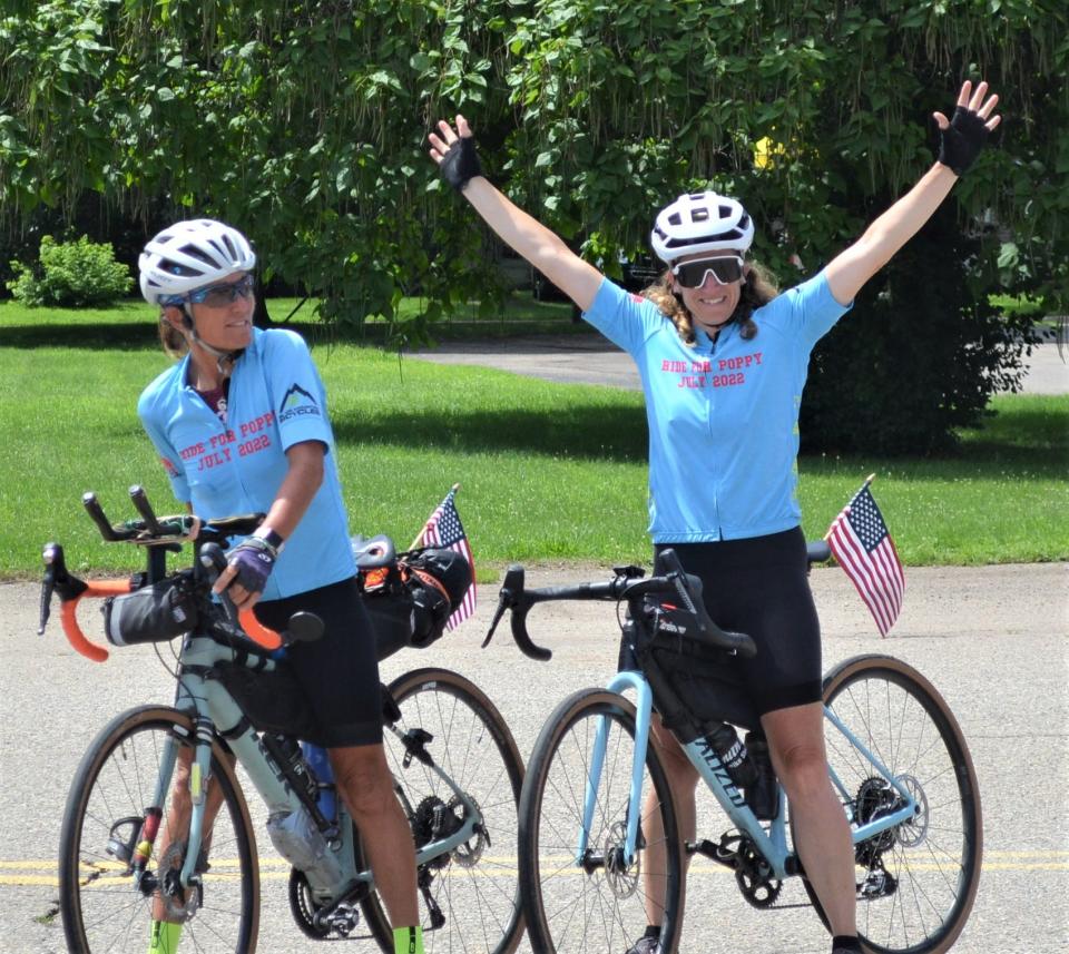 Battle Creek's Nicole Jaeger reacts to her reception after riding into town on Tuesday as she nears the end of her 2,000-plus mile 'Ride For Poppy' that has seen her ride her bike, along with teammate Sylvia Maas, left, from Oregon to Michigan in an effort to raise money for cancer research in honor of her late father.