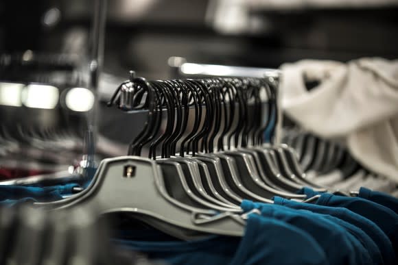 Blue and white shirts hanging on a clothing display rack