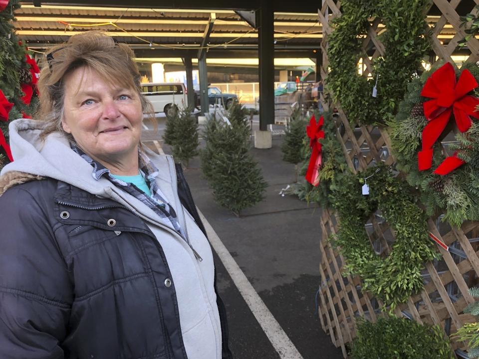In this Saturday, Dec. 7, 2019 photo, Sandy Parsons is shown at her seasonal stand, at the Capitol Market in Charleston, W.Va. Parsons never received her order of 350 trees this year from a North Carolina farm, citing a short supply. Instead, she was sent a few much-smaller trees to sell at her lot. Christmas trees are in tight supply again this year across the United States, depending upon location and seller, as the industry continues bouncing back from the Great Recession. (AP Photo/John Raby)
