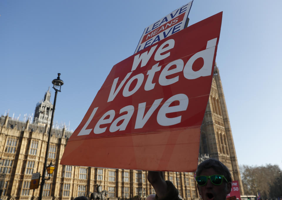 A supporter of leaving the European Union holds up a placard as he take part in a demonstration outside the Palace of Westminster in London, Wednesday, Feb. 27, 2019. British Prime Minister Theresa May says she will give British lawmakers a choice of approving her divorce agreement, leaving the EU March 29 without a deal or asking to delay Brexit by up to three months. (AP Photo/Alastair Grant)