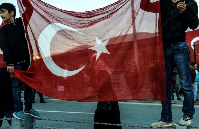 Youths hold a Turkish flag during a gathering outside the Vodafone Arena football stadium in Istanbul on December 11, 2016