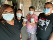 In this June 4, 2020 photo provided by Shannon Todecheene, Todecheene, left, her sister, Erin Gonzales, second from left and her mother, Carol Todecheene, with her brother, Randon Austin, and the family dogs pose in Tucson, Ariz. Carol Todecheene was among those severely hit with the coronavirus. (Shannon Todecheene via AP)