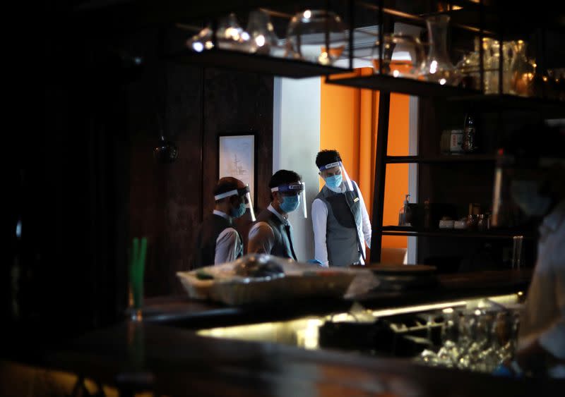 Servers wearing protective face shields are seen at a restaurant as India eases lockdown restrictions that were imposed to slow the spread of the coronavirus disease (COVID-19), in New Delhi