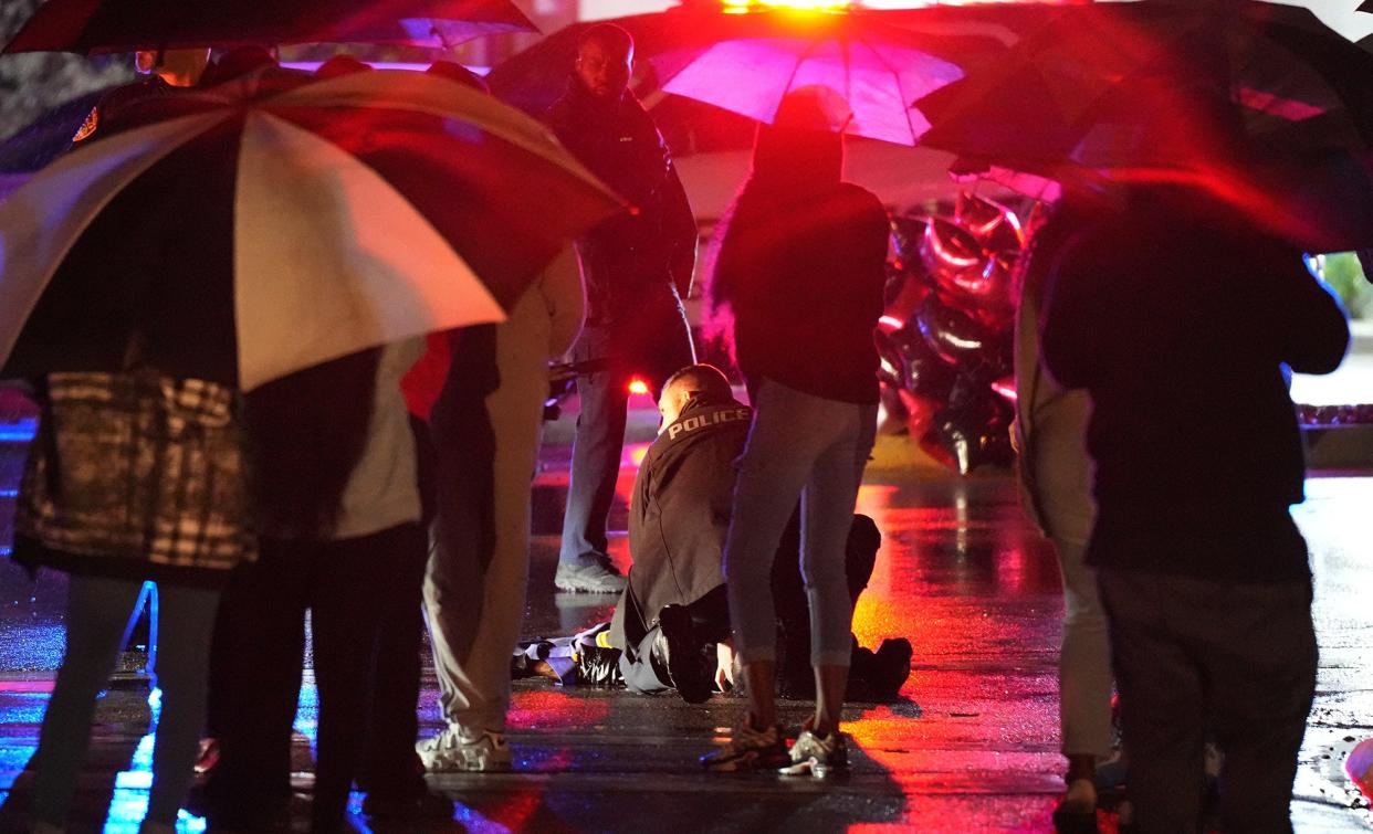 A police officer helps Bishop Bernard Wright after he was hit by a car following a vigil marking one year since the death of Stanley Davis III.