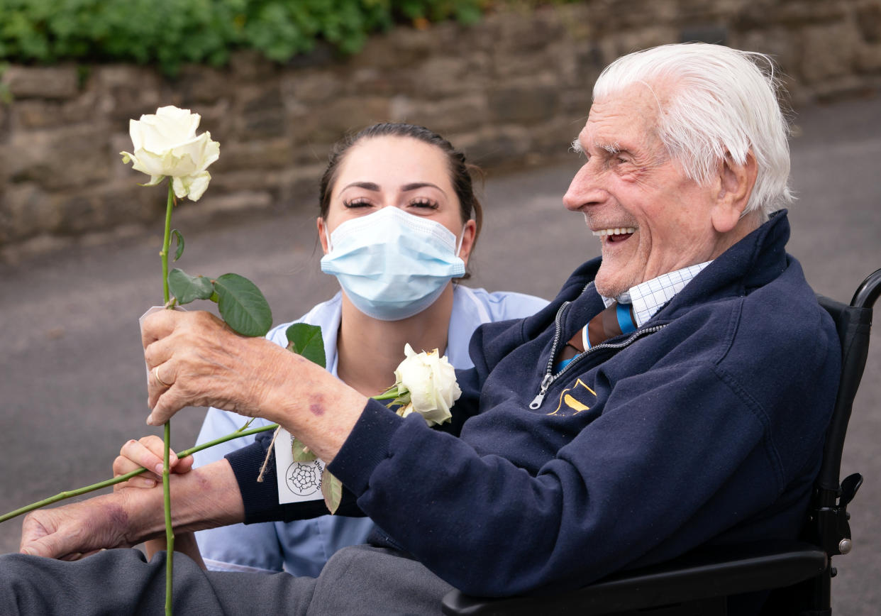 Health Care Assistant Rose Waddington and ninety-eight-year-old resident John Kykot are pictured with 