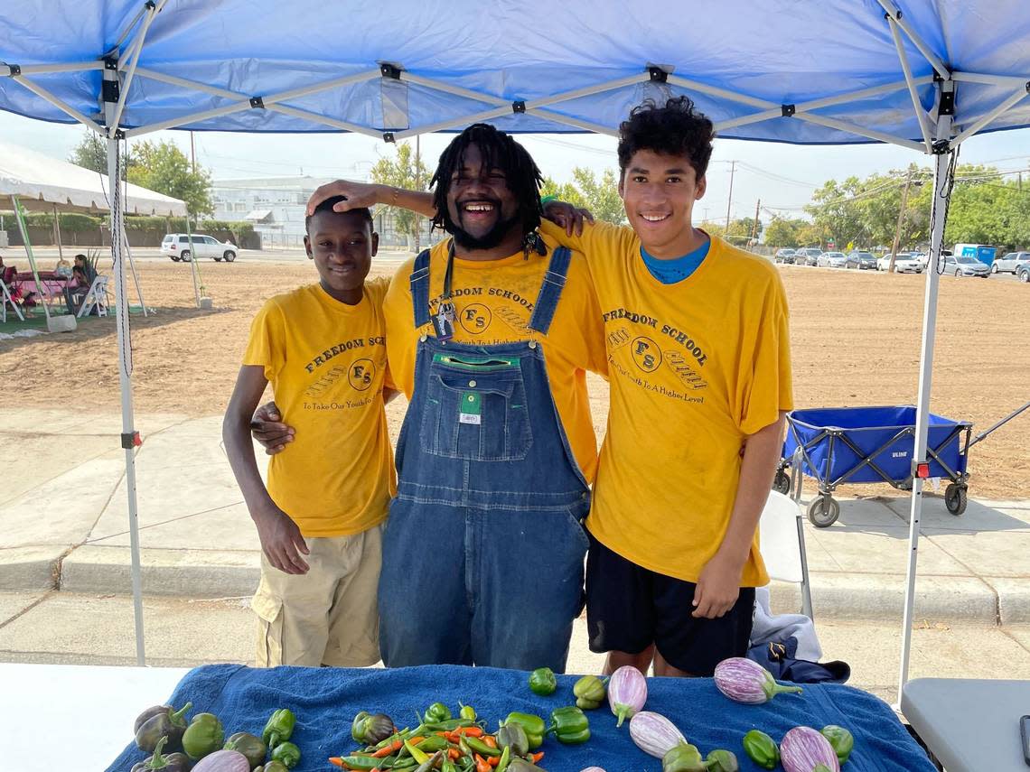 Harris and two Fresno Freedom School students sell vegetables at the West Fresno CAN 93706 Market on Sept 9, 2022. Fresno Freedom School students help grow the produce and back boxes as part of the school’s agriculture program.