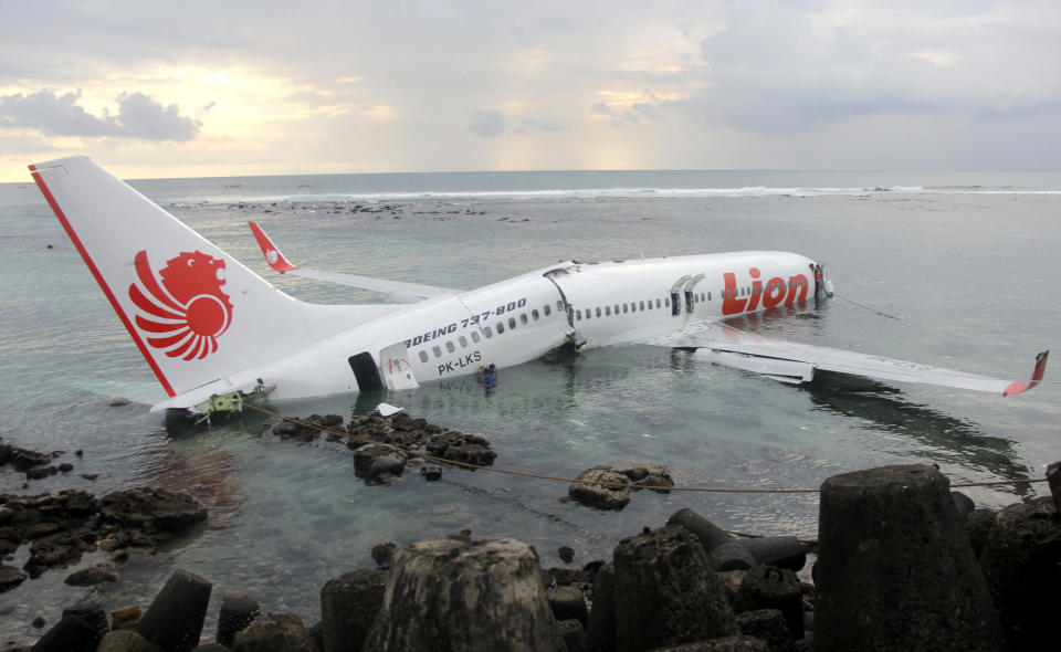 En una foto proporcionada por la Policía de Indonesia, los restos de un avión de la línea aérea Lion Air se encuentra en el agua tras salirse de la pista del aeropuerto de Bali, Indonesia el sábado 13 de abril de 2013. (AP Foto/Indonesian Police)