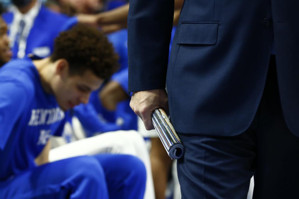 Kentucky basketball coach John Calipari coached the first possession of UK's win over Tennessee with a rolled up program in his hand in honor of former coach Joe B. Hall, who died Saturday.