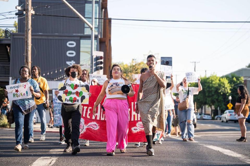 The Asian American Liberation Network’s Daisha Alexander, center, marches with Rohan Zhou-Lee, right, founder of the Blasian March in New York, during Sacramento’s first Blasian March on Saturday, Aug. 5, 2023, in Oak Park. The event included the march through the neighborhood, a book fair and unveiling of a mural in honor of Darrell Richards, a 19-year-old Black and Hmong man shot and killed by Sacramento Police Department officers in 2018.