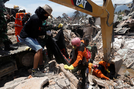 A victim of last week's earthquake is recovered in the Balaroa neighbourhood in Palu, Central Sulawesi, Indonesia October 6, 2018. REUTERS/Darren Whiteside