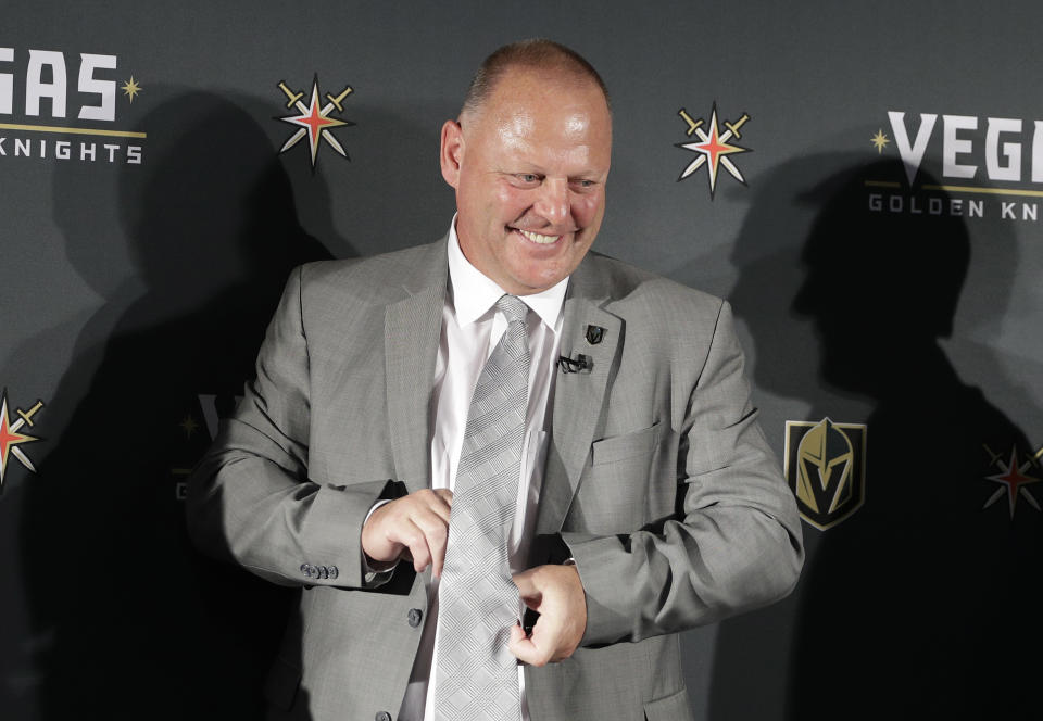 Gerard Gallant adjusts his tie during a news conference Thursday, April 13, 2017, in Las Vegas. The Vegas Golden Knights have hired Gallant as the first coach of the NHL expansion team. (AP Photo/John Locher)