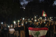 Demonstrators march holding candles and flashlights honoring the victims of the deadly explosion at Beirut port which devastated large parts of the capital, in Beirut, Lebanon, Sunday, Aug. 9, 2020. (AP Photo/Felipe Dana)