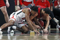 Texas Tech's Chibuzo Agbo (23) and Eastern Washington's Rylan Bergersen (11) dive for the loose ball during the second half of an NCAA college basketball game on Wednesday, Dec. 22, 2021, in Lubbock, Texas. (AP Photo/Brad Tollefson)