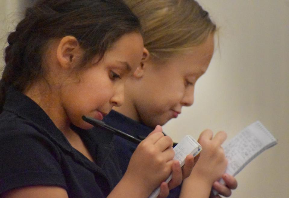 Jurors from left, Aryana DeSa and Sloan Souza, students at Mastery School of Independent Learning, take notes during the mock trial Thursday,