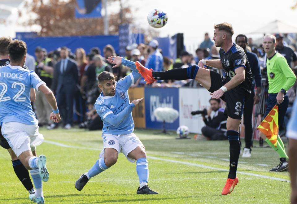 CF Montreal midfielder Djordje Mihailovic kicks the ball away from NYFC forward Kevin O'Toole during the first half of an MLS Eastern Conference semifinals soccer game in Montreal, Sunday, Oct. 23, 2022. (Paul Chiasson/The Canadian Press via AP)