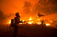 A firefighter works against the Lake Hughes fire in Angeles National Forest on Wednesday, Aug. 12, 2020, north of Santa Clarita, Calif. (AP Photo/Ringo H.W. Chiu)