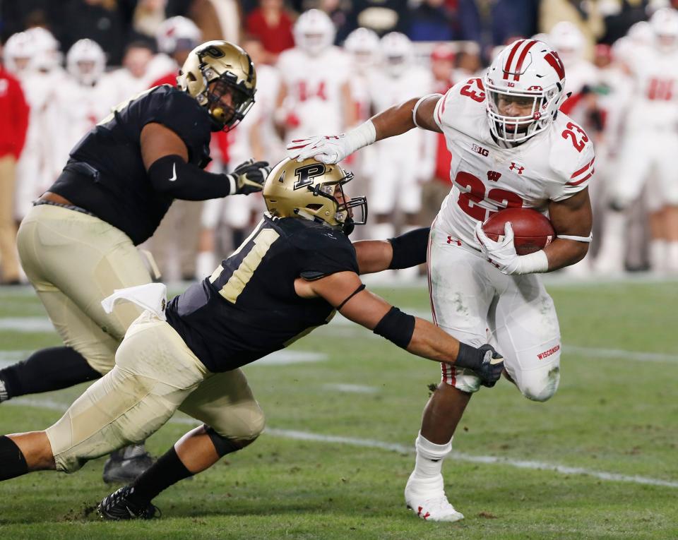 Jonathan Taylor of Wisconsin gets past Markus Bailey of Purdue on a second half carry Saturday, November 17, 2018, at Ross-Ade Stadium. Wisconsin won, 47-44, in triple overtime.