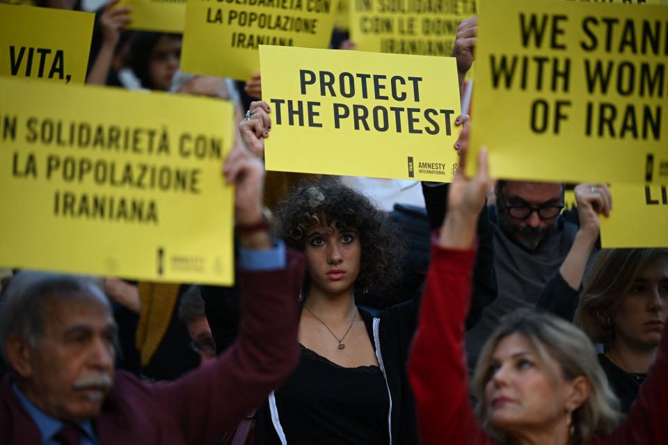 Protesters hold slogans during a demonstration in solidarity with Iranian women and protestors in Piazza del Campidoglio in Rome on October 5, 2022, following the death of Kurdish Iranian woman Mahsa Amini.