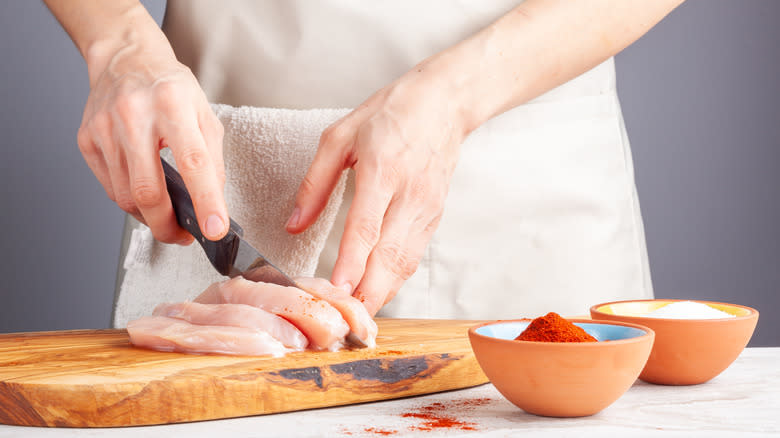 Cutting chicken breast with cayenne pepper