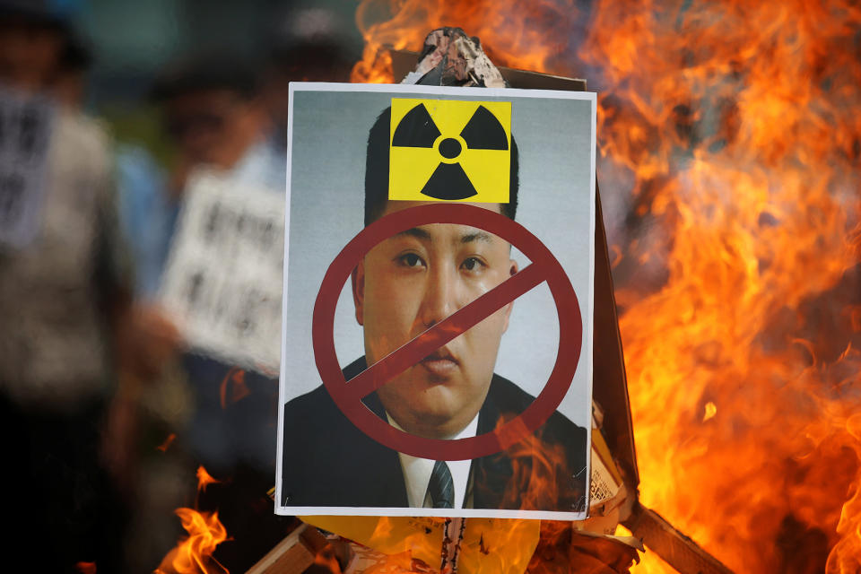 A cut-out of North Korean leader Kim Jong Un is set on fire during an anti-North Korea rally in central Seoul