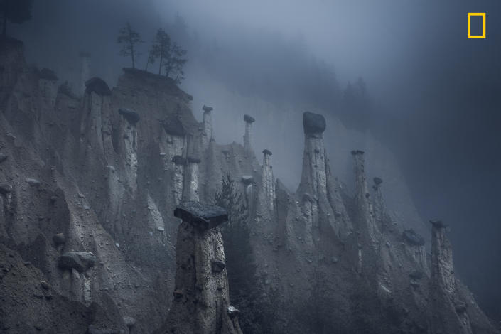 <p>Photograph and caption by Marco Grassi/National Geographic Travel Photographer of the Year Contest. — “These natural sand towers, capped with large stones, are known as the Earth Pyramids of Platten. They are situated in Northern Italy’s South Tyrol region. Formed centuries ago after several storms and landslides, these land formations look like a landscape from outer space and continuously change over the years and, more accurately, over seasons. This natural phenomenon is the result of a continuous alternation between periods of torrential rain and drought, which have caused the erosion of the terrain and the formation of these pinnacles. As the seasons change, the temperatures move between extremes and storms affect the area, pyramids disappear over time, while new pinnacles form as well.” Brunico, South Tyrol, Italy. </p>