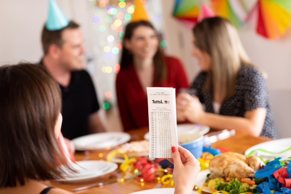 Winning lotto ticket and people wearing party hats. Source: The Lott