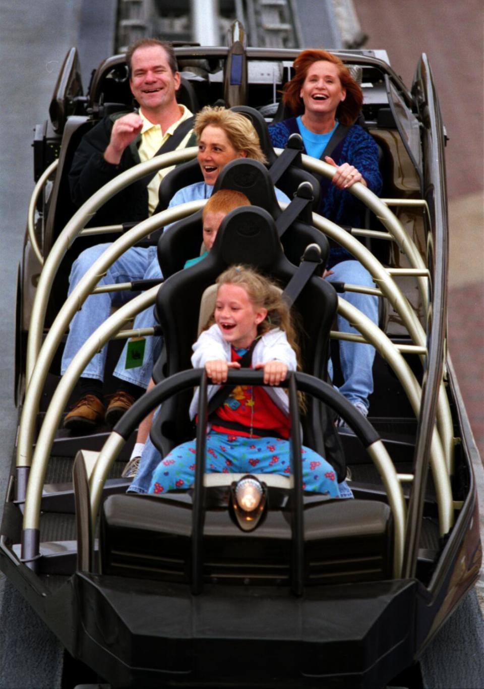 A group of people riding a rocket-themed ride at Disneyland.