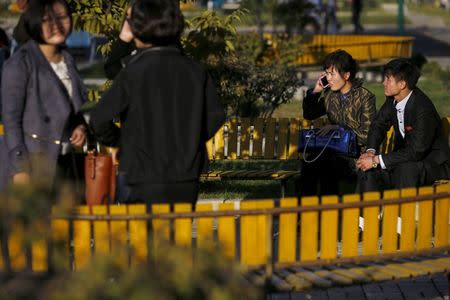 People enjoy nice weather at a park in front of the Pothonggang Department Store in central Pyongyang October 11, 2015. REUTERS/Damir Sagolj