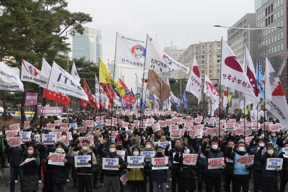 Members of the Korean Confederation of Trade Unions stage a rally against the government's labor policy near the National Assembly in Seoul, South Korea, Saturday, Dec. 3, 2022. Thousands of demonstrators representing organized labor marched in South Korea's capital on Saturday denouncing government attempts to force thousands of striking truckers back to work after they walked out in a dispute over the price of freight. The cards read "Stop the worsening of labor laws." (AP Photo/Ahn Young-joon)