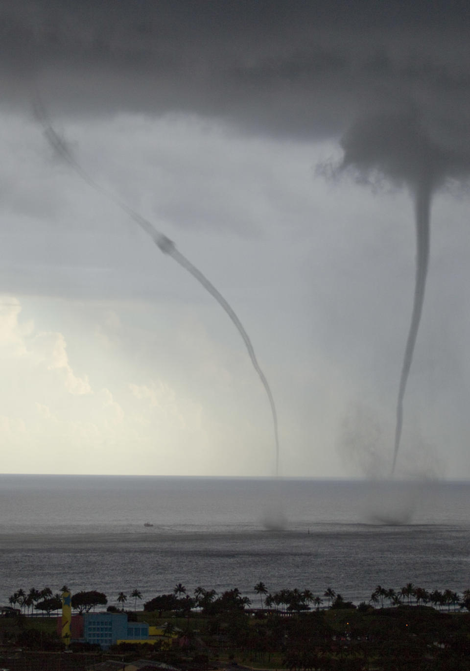 Two water spouts can be seen about a mile off shore south of downtown Honolulu Monday, May 2, 2011. (AP Photo/Eugene Tanner)