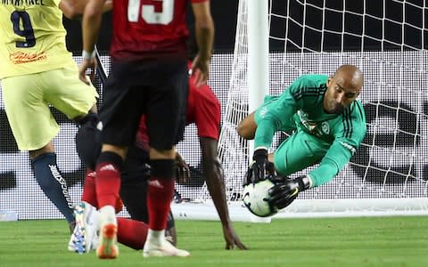 Manchester United goal keeper Lee Grant, right, makes a save on the shot by Club America forward Roger Martinez  - Credit: AP