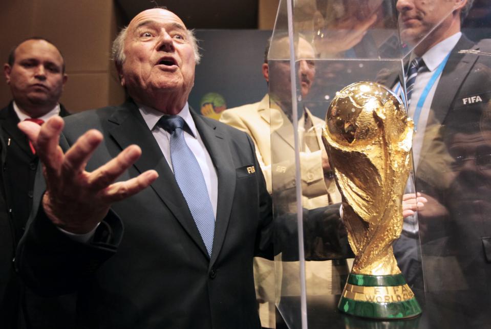 FIFA President Sepp Blatter gestures next to the World Cup trophy after a media conference in Sao Paulo June 5, 2014. The 2014 World Cup will be held in 12 cities in Brazil from June 12 to July 13. REUTERS/Paulo Whitaker (BRAZIL - Tags: SPORT SOCCER WORLD CUP TPX IMAGES OF THE DAY)