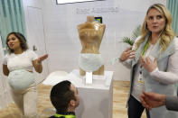 People look at the Owlet Band pregnancy monitor at the Owlet booth at CES International, Wednesday, Jan. 9, 2019, in Las Vegas. The device can track fetal heart rate, kicks and contractions. (AP Photo/John Locher)