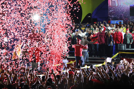 Confetti falls as supporters walk up to greet Venezuela's President Nicolas Maduro (center, R, in red) during a gathering after the results of the election were released, outside of the Miraflores Palace in Caracas, Venezuela, May 20, 2018. REUTERS/Carlos Garcia Rawlins