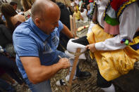 <p>An assistant helps a dancer to prepare for taking part in stilts performance in honor of Saint Mary Magdalene in a street for the traditional “Danza de Los Zancos” (Los Zancos Dance), in the small town of Anguiano, northern Spain, July 23, 2016. (AP Photo/Alvaro Barrientos)</p>